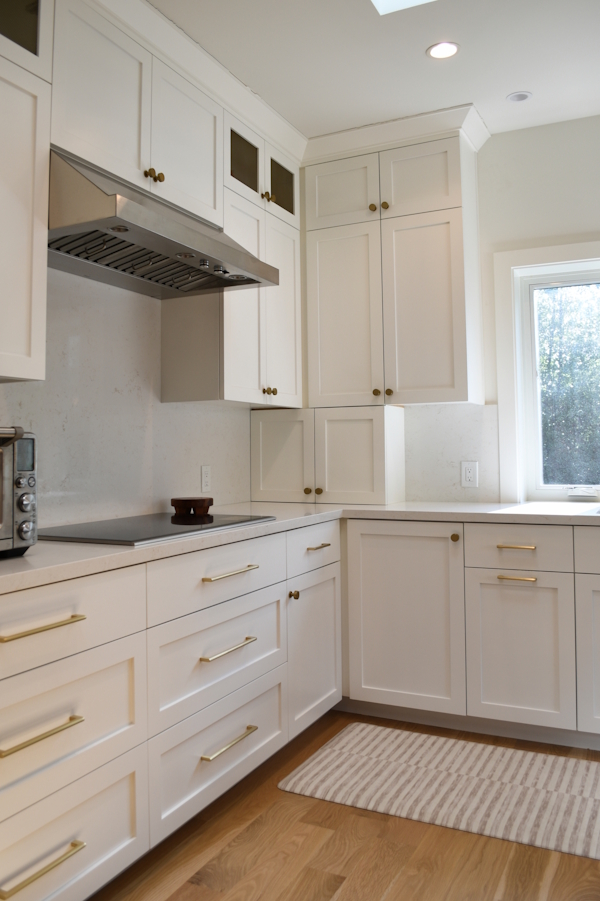 White kitchen cabinetry and range wall